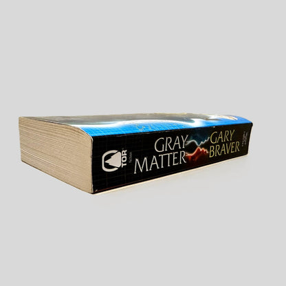 Close-up spine view of Gray Matter by Gary Braver centered on a neutral light gray background. Spine shows minimal creasing. Pages lay flat.