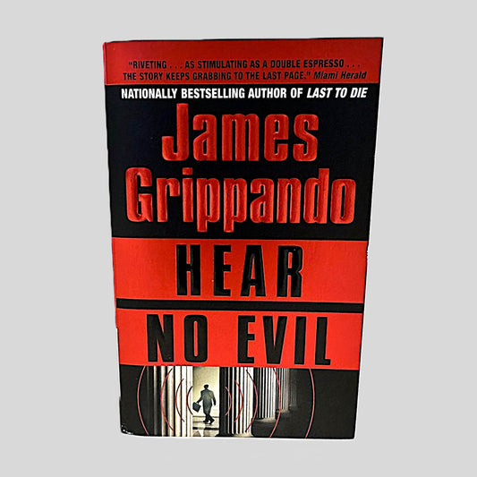 Front cover view of Hear No Evil by James Grippando centered on a neutral light gray background. Cover is in pristine condition.