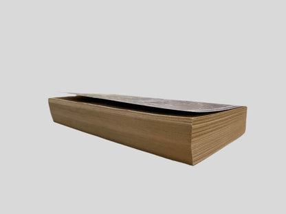 Close-up page edge view of Hour Game by David Baldacci centered on a neutral light gray background. Pages are crisp and lay flat.