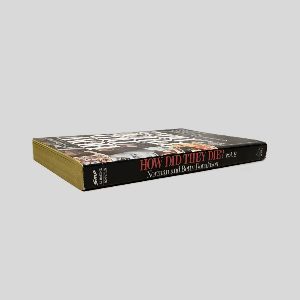 Close-up spine view of How Did They Die Vol 2 by Donaldson centered on a neutral light gray background. The spine shows minimal creasing and is square.