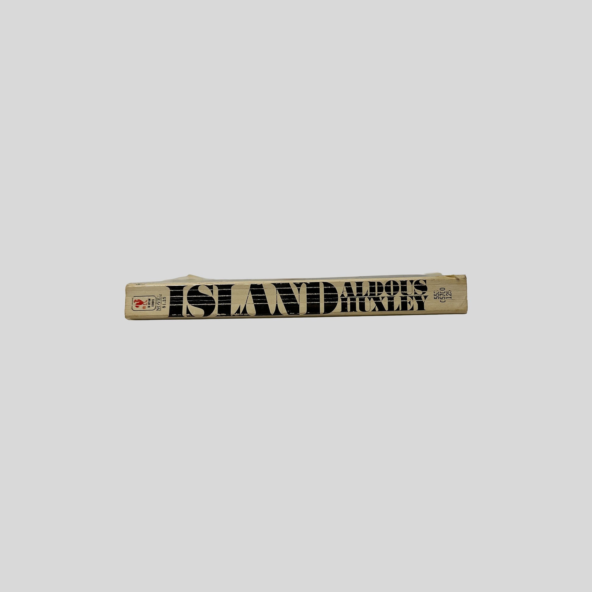The tan-colored spine of the Bantam book "Island" by Aldous Huxley, showing vertical title text and the publisher's rooster logo.