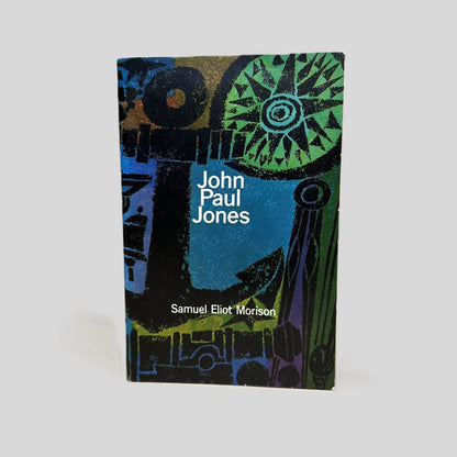Front cover view of John Paul Jones A Sailor’s Biography by Samuel Eliot Morison centered on a neutral light gray background. Minor creasing near the top edge. Small chip to the bottom right corner. Cover art is vibrant.