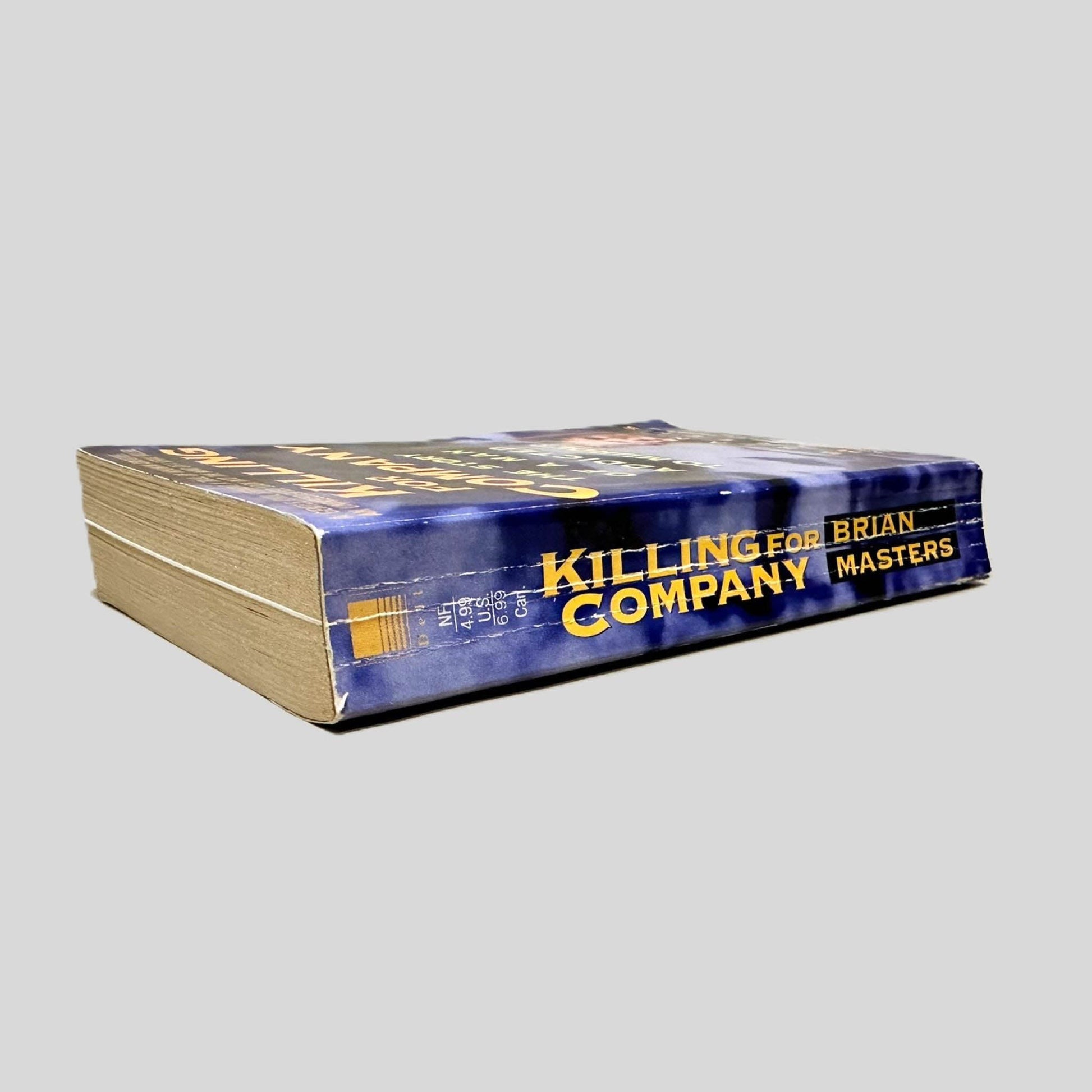 Close-up spine view of Killing for Company by Brian Masters centered on a neutral light gray background. Spine shows creasing.