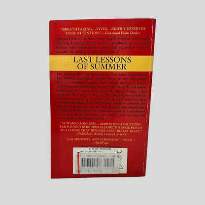 Back cover view of Last Lessons of Summer by Margaret Maron centered on a neutral light gray background. Creasing is present along the spine edge.