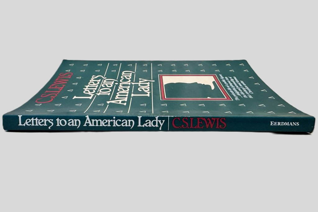 Close-up spine view of Letters to an American Lady by C.S. Lewis centered on a neutral light gray background. Spine shows no creasing. 