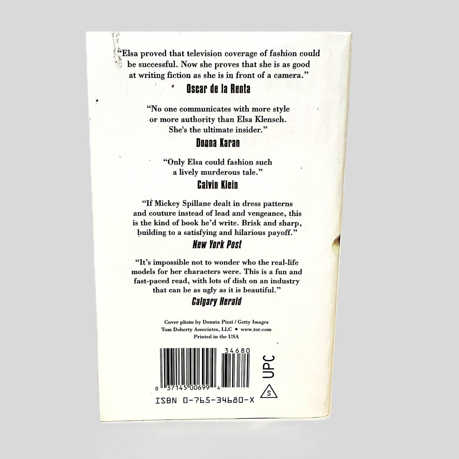Back cover view of Live at 10:00, Dead at 10:15 by Elsa Klensch centered on a neutral light gray background. 