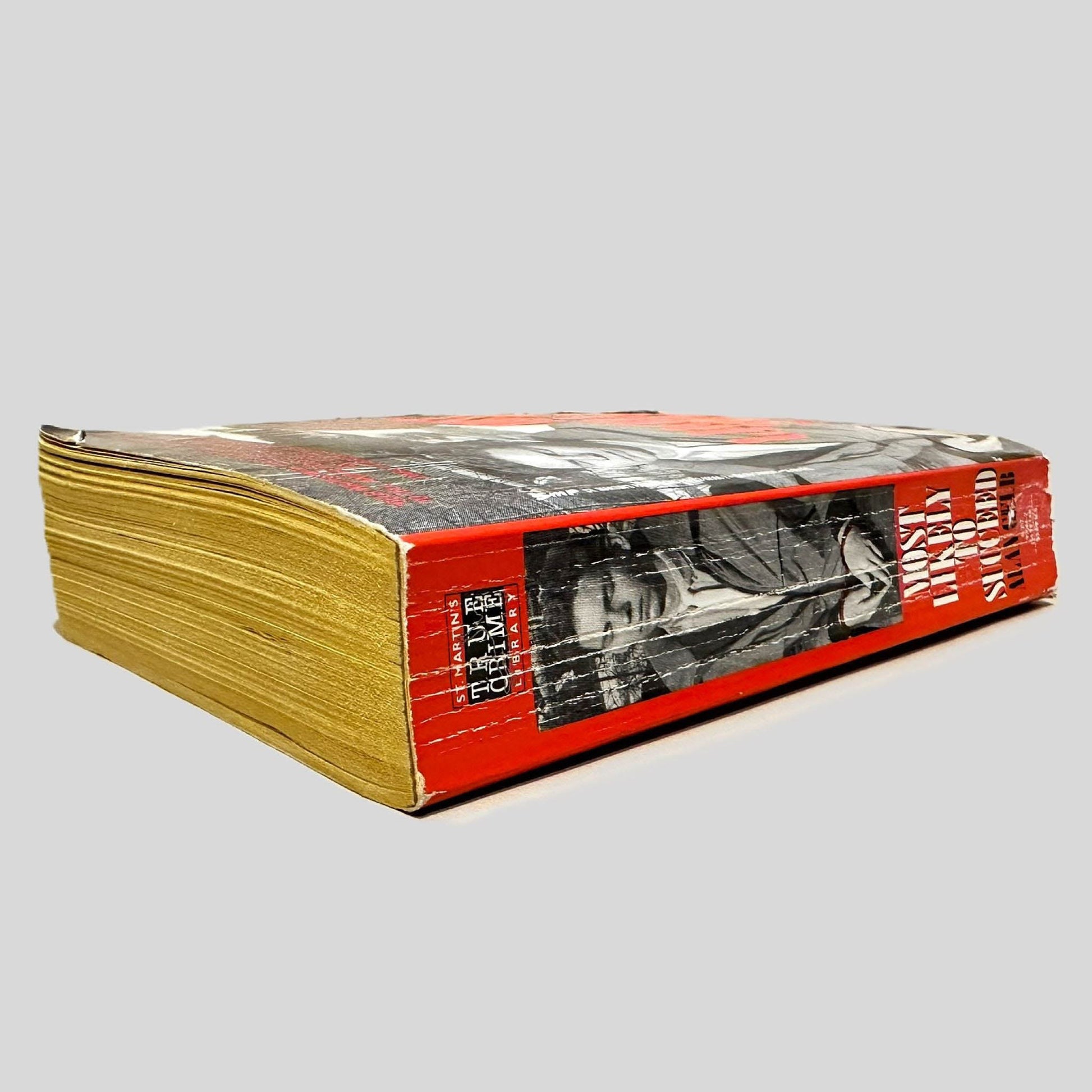 Close-up spine view of Most Likely to Succeed by Alan Gelb centered on a neutral light gray background. Spine shows creasing and chipping.