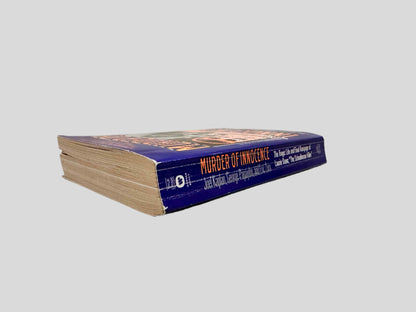 Close-up spine view of Murder of Innocence by Joel Kaplan, George Papajohn, & Eric Zorn centered on a neutral light gray background. Spine shows creasing.