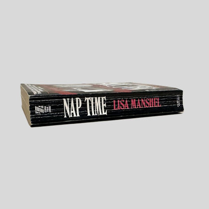 Close-up spine view of Nap Time by Lisa Manshel centered on a neutral light gray background. Spine shows creasing.
