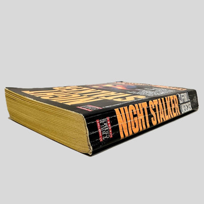 Close-up spine view of Night Stalker by Clifford L. Linedecker centered on a neutral light gray background. Spine shows creasing and rubbing.