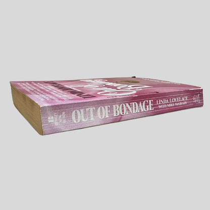 Close-up spine view of Out of Bondage by Linda Lovelace centered on a neutral light gray background. Spine shows creasing.