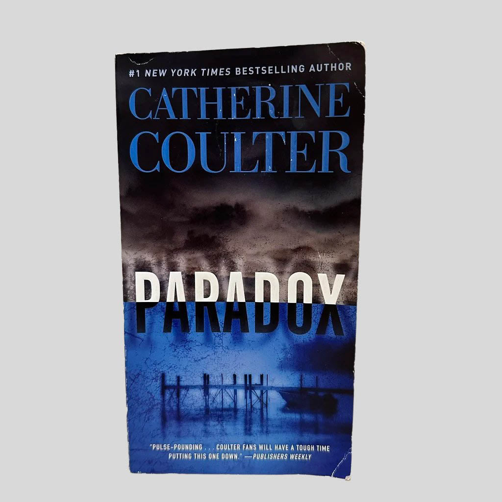 Front cover view of Paradox by Catherine Coulter centered on a neutral light gray background. Shows some creasing on the corners.