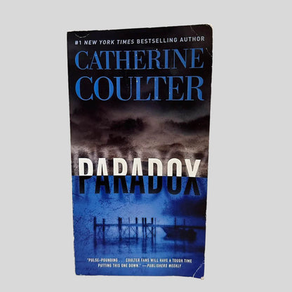 Front cover view of Paradox by Catherine Coulter centered on a neutral light gray background. Shows some creasing on the corners.