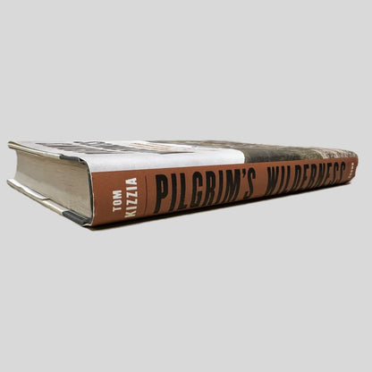 Close-up spine view of Pilgrim's Wilderness by Tom Kizzia centered on a neutral light gray background. 