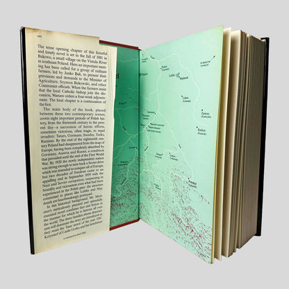 Inside front cover view of Poland A Novel by James A. Michener centered on a neutral light gray background. Dust jacket is present and price is clipped. Pages are crisp.