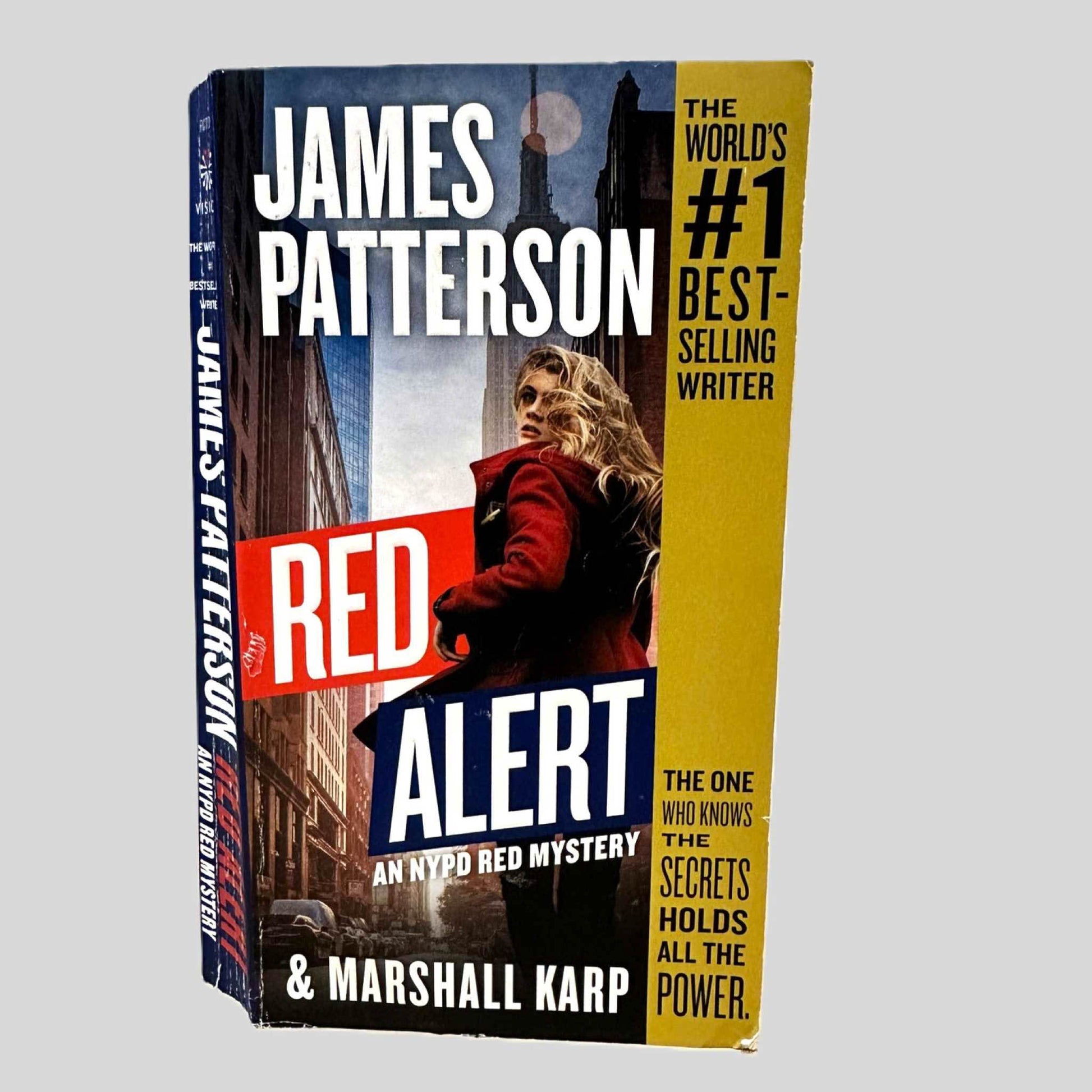 Front cover view of Red Alert by James Patterson centered on a neutral light gray background. Cover shows chipping in the bottom corner.