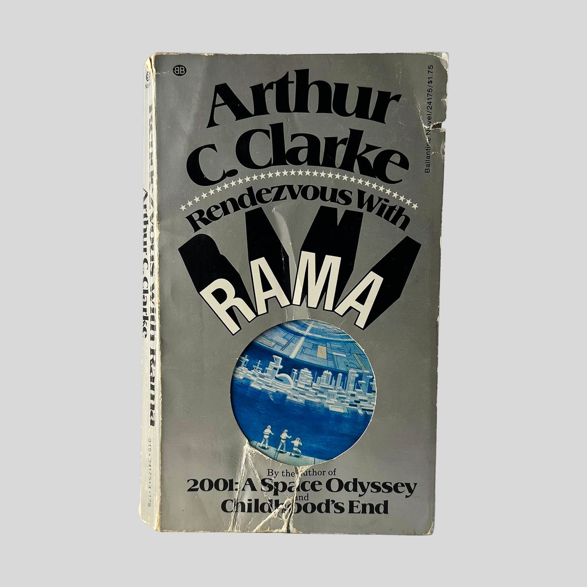 Front cover view of Rendezvous With Rama by Arthur C. Clarke centered on a neutral light gray background. Significant chipping to bottom center and top right edge. Additional chipping is present at the oop front of the spine corner.
