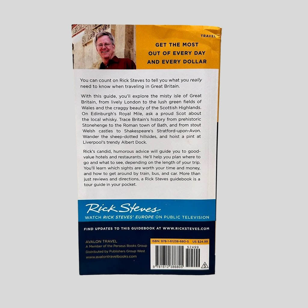 Back cover view of Rick Steves Great Britain 20th Edition centered on a neutral light gray background. Bumping and creasing to the top left spine corner.