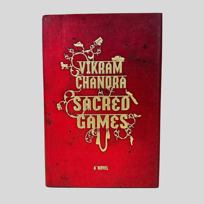 Front cover view of Sacred Games by Vikram Chandra centered on a neutral light gray background. Dust jacket present and undamaged.