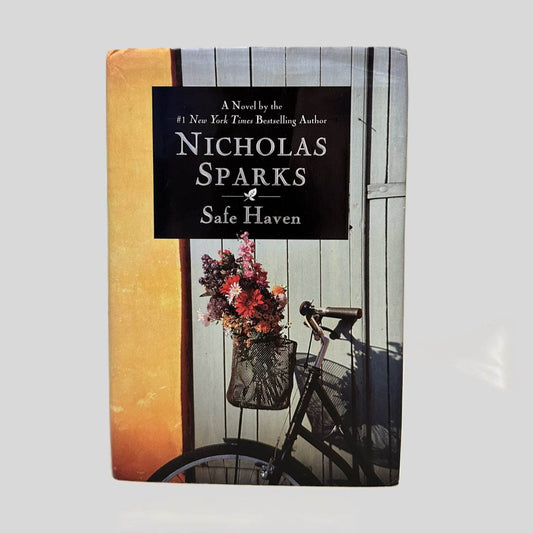 Front cover view of Safe Haven by Nicholas Sparks centered on a neutral light gray background. Dust jacket is present. Some creasing is present at the top of the dust jacket.