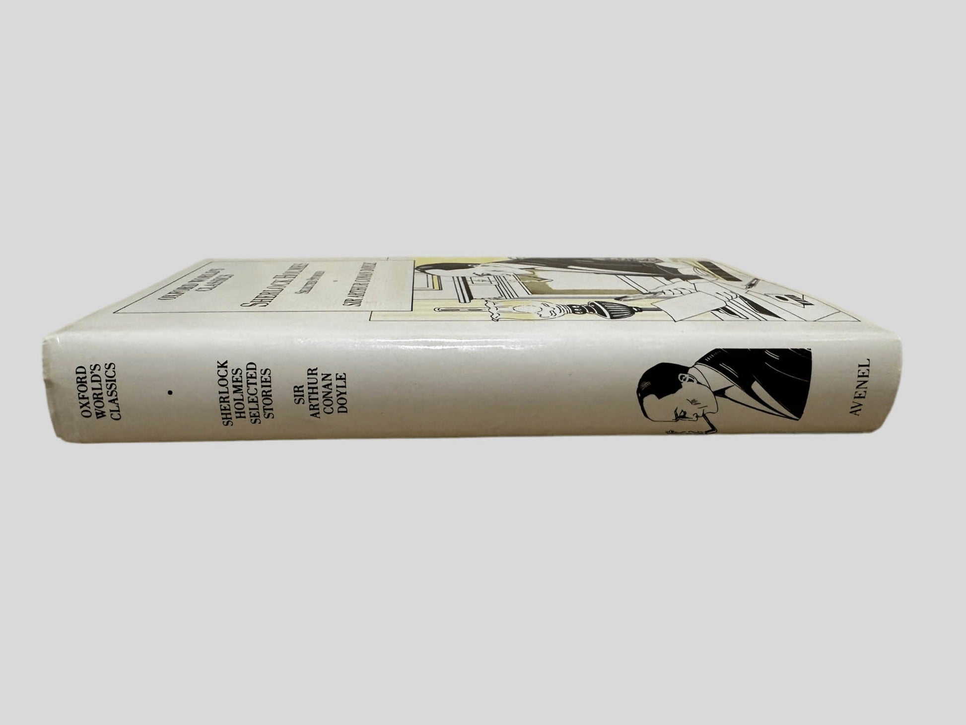 Close-up spine view of Sherlock Holmes Selected Stories by Sir Arthur Conan Doyle centered on a neutral light gray background. Dust jacket is present and shows no damage. Spine shows no creasing. Pages lay flat.