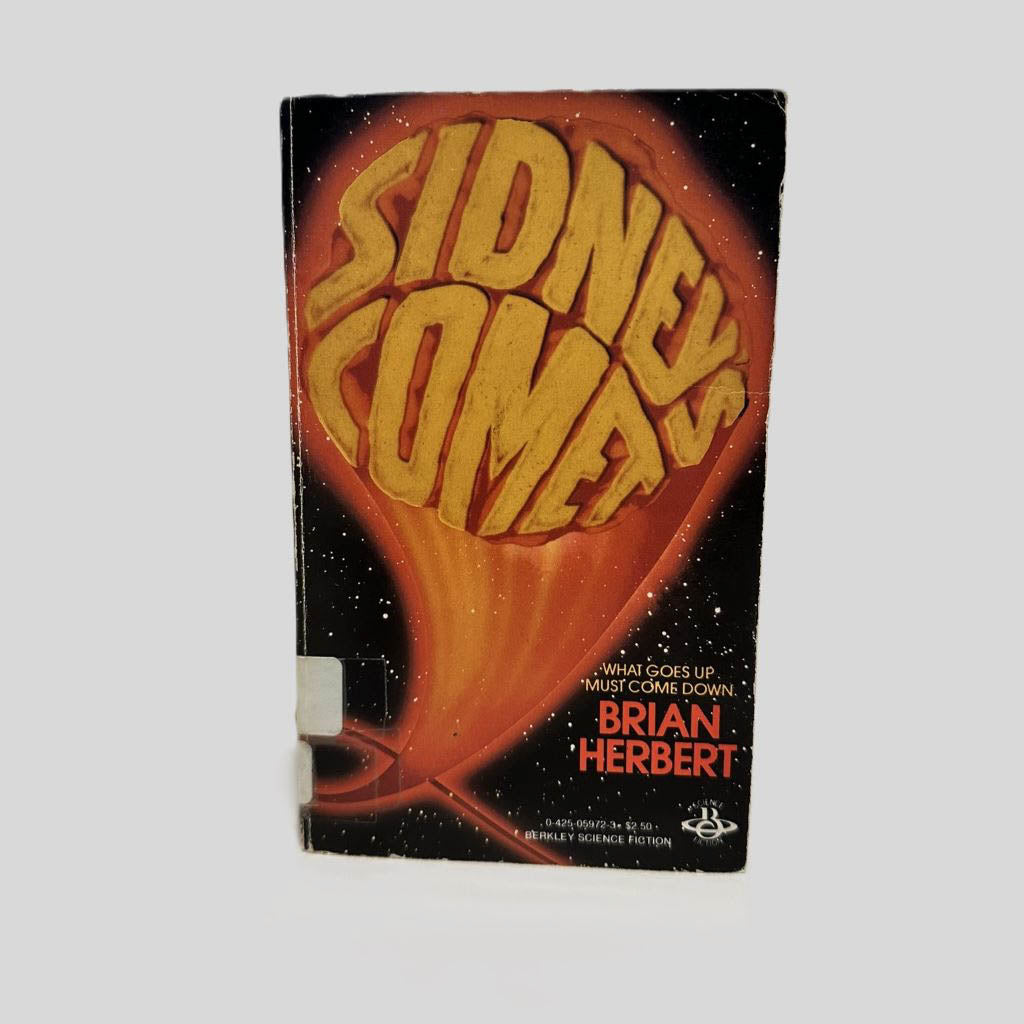 Front cover view of Sidney's Comet by Brian Herbert centered on a neutral light gray background. Chipping is present around the edges. Creasing near the spine.