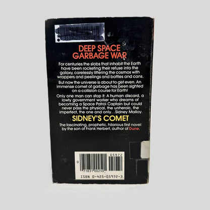 Back cover view of Sidney's Comet by Brian Herbert centered on a neutral light gray background. Chipping and creasing are present on the corners. Library barcode sticker in the top left corner, colored over with black ink. 