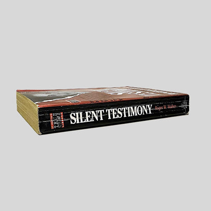 Close-up spine view of Silent Testimony by Roger W. Walker centered on a neutral light gray background. Spine shows creasing.