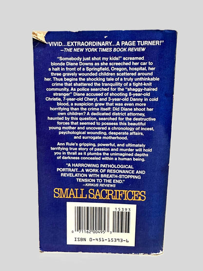 Back cover view of Small Sacrifices by Ann Rule centered on a neutral light gray background. Top corner as a small tear.