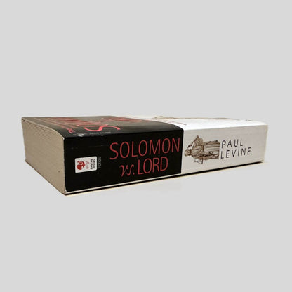 Close-up spine view of Solomon vs. Lord by Paul Levine centered on a neutral light gray background. Spine shows minimal creasing.