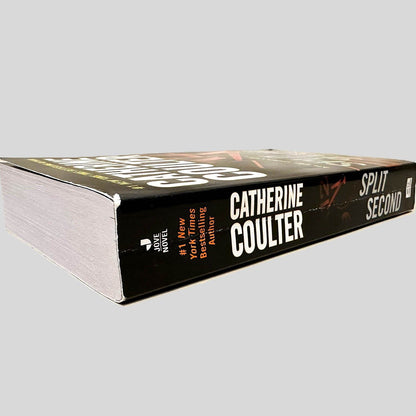 Close-up spine view of Split Second by Catherine Coulter centered on a neutral light gray background. Spine is square, shows minor creasing. Pages lay flat.