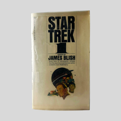 Front cover view of Star Trek 1 adapted by James Blish centered on a neutral light gray background. Library mylar cover is present to protect the book. 