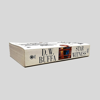 Close-up spine view of Star Witness by D.W. Buffa centered on a neutral light gray background. Spine is square and shows minimal creasing. Pages lay flat.