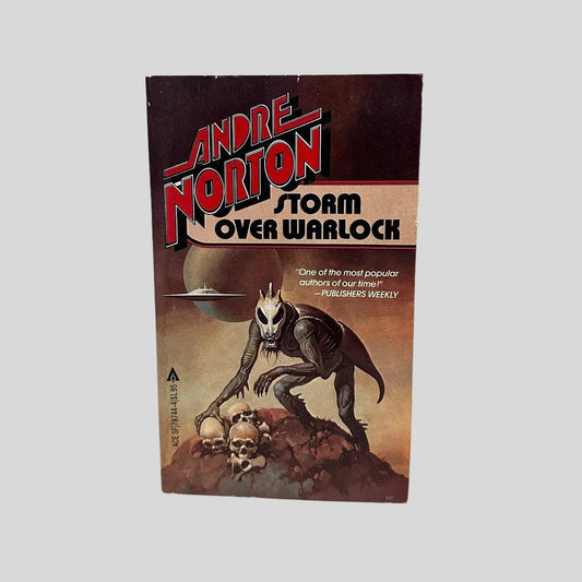 Front cover view of Storm Over Warlock by Andre Norton centered on a neutral light gray background. Minor chipping is present around the edges from age. Cover art is vibrant. 