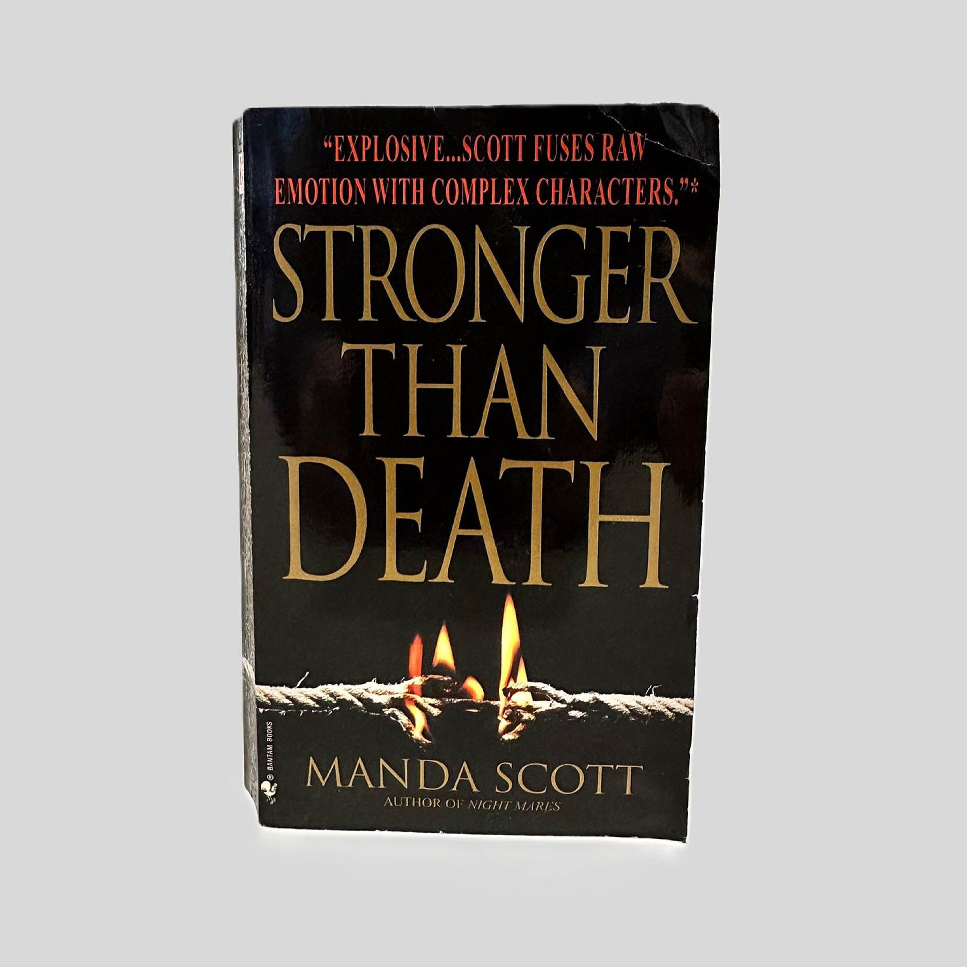 Front cover view of Stronger Than Death by Manda Scott centered on a neutral light gray background. Top right corner shows bumping and creasing.