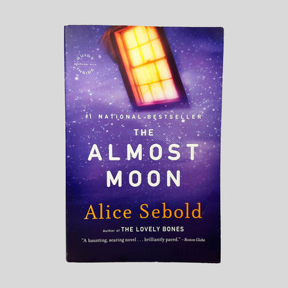 Front cover view of The Almost Moon by Alice Sebold centered on a neutral light gray background. Normal chipping from wear is present around the edges.