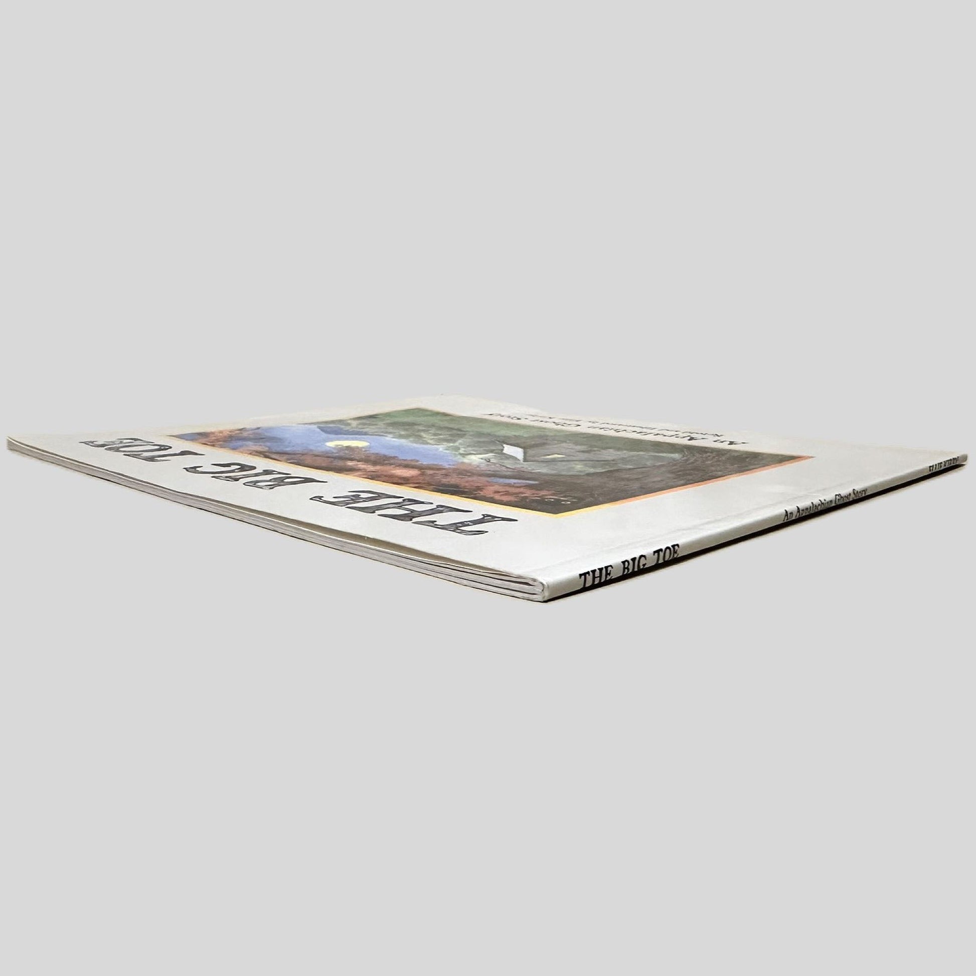 Angle view showing the page edges of The Big Toe by Ellie Kirby centered on a neutral light gray background. 