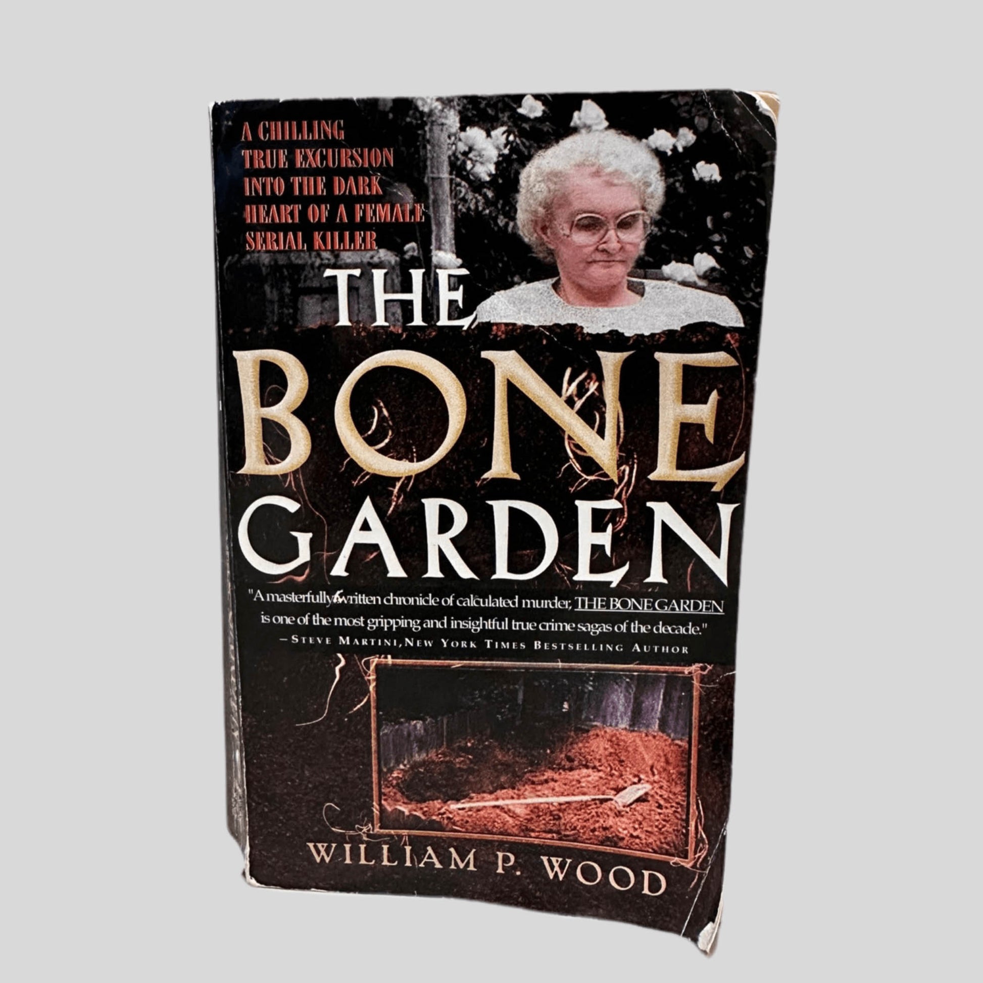 Front cover view of The Bone Garden by William P. Wood centered on a neutral light gray background. Cover shows creasing and rubbing.