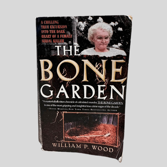 Front cover view of The Bone Garden by William P. Wood centered on a neutral light gray background. Cover shows creasing and rubbing.