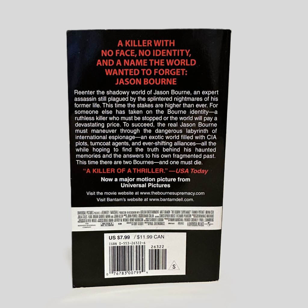 Back cover view of The Bourne Supremacy by Robert Ludlum centered on a neutral light gray background. 