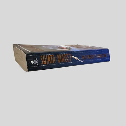 Close-up spine view of The Bride's Kimono by Sujata Massey centered on a neutral light gray background. Spine shows creasing. Pages lay flat.