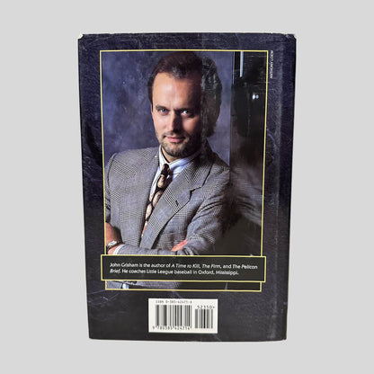 Back cover view of The Client by John Grisham centered on a neutral light gray background. Dust jacket is present and shows normal wear.