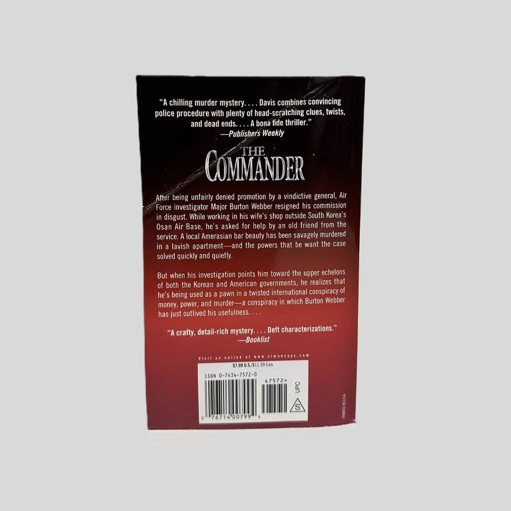 Back cover view of The Commander by Patrick A. Davis centered on a neutral light gray background. Creasing along top corner.