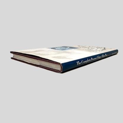 Close-up spine view of The Complete Poems of Edgar Allan Poe centered on a neutral light gray background. 