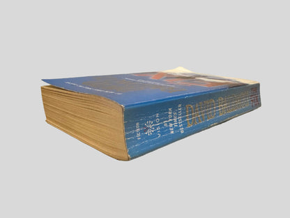 Close-up spine view of The Fix by David Baldacci centered on a neutral light gray background. Spine shows creasing. Pages lay flat.