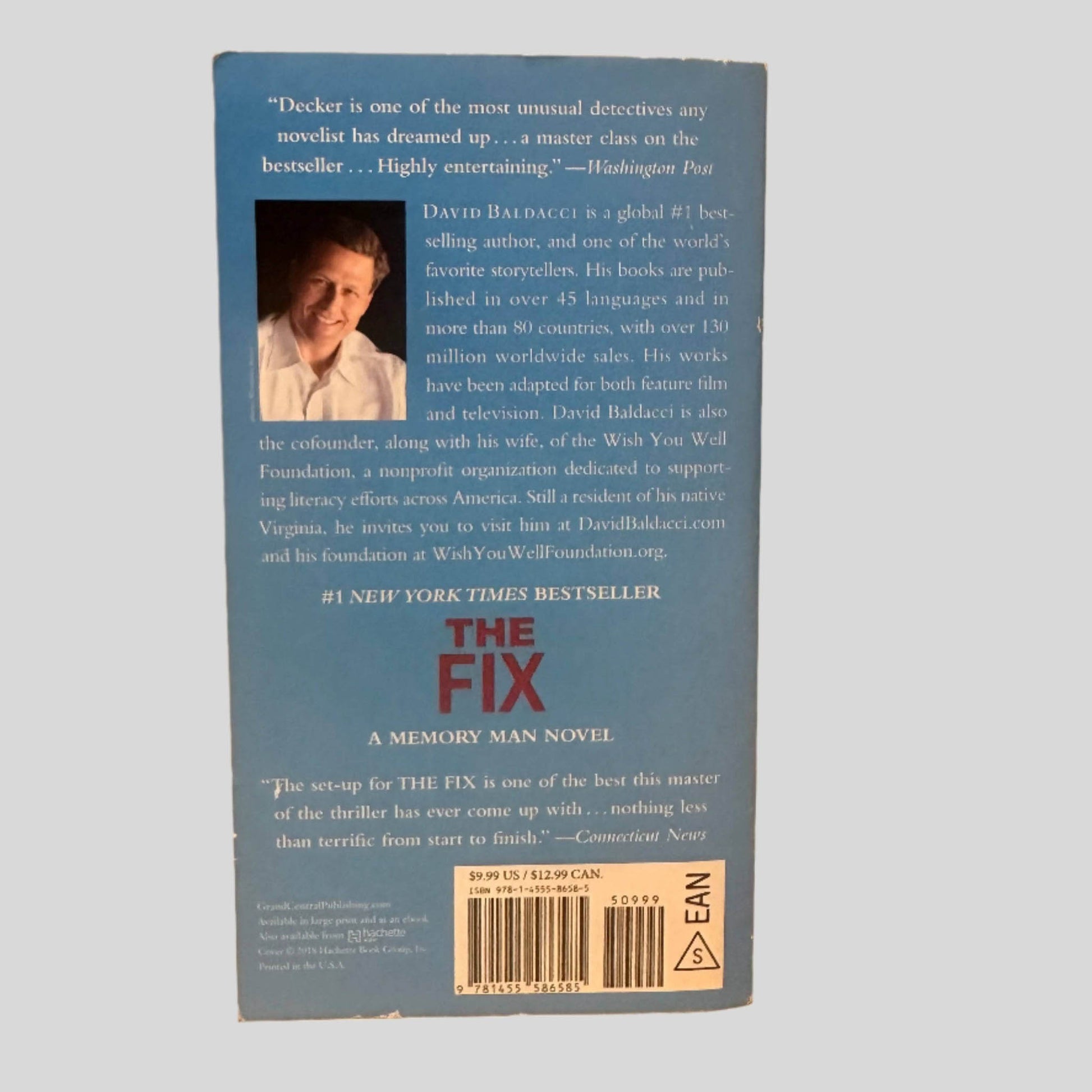 Back cover view of The Fix by David Baldacci centered on a neutral light gray background. Edges of cover show some chipping.