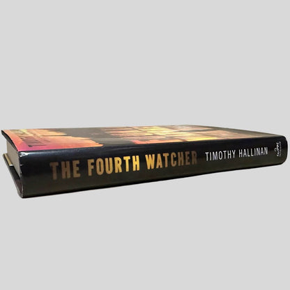 Close-up spine view of The Fourth Watcher by Timothy Hallinan centered on a neutral light gray background. Dust jacket is present and undamaged.