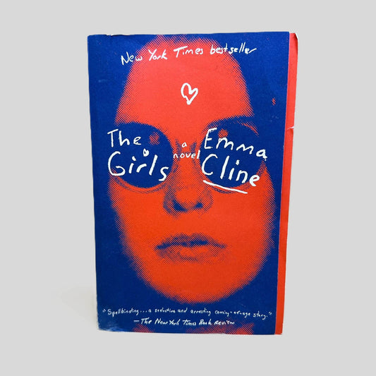 Front cover view of The Girls by Emma Cline centered on a neutral light gray background. Top corner is creased.