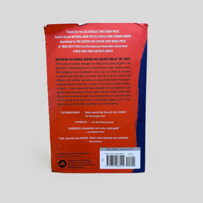 Back cover view of The Girls by Emma Cline centered on a neutral light gray background. Chipping along top edge. Bumping on top right corner of spine. Creasing across top left corner.
