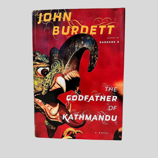 Front cover view of The Godfather of Kathmandu by John Burdett centered on a neutral light gray background. Dust jacket present and undamaged.
